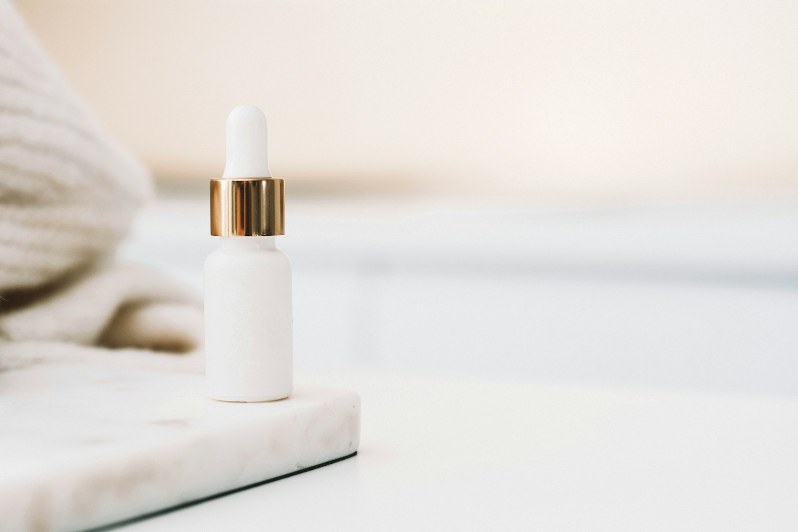 White skincare bottle on a bright neutral surface